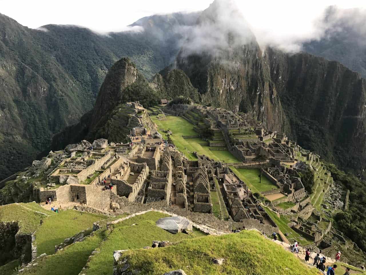 about-02 Stunning aerial view of Machu Picchu with lush mountains and clouds in the background.